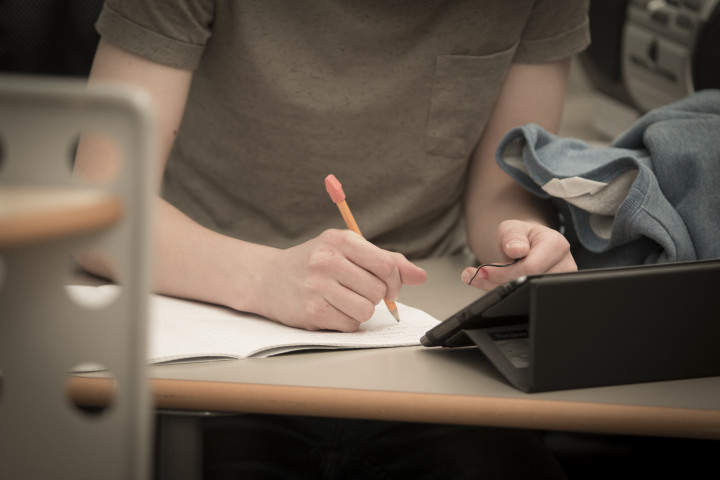 Ung man studerar matematik framför surfplatta.