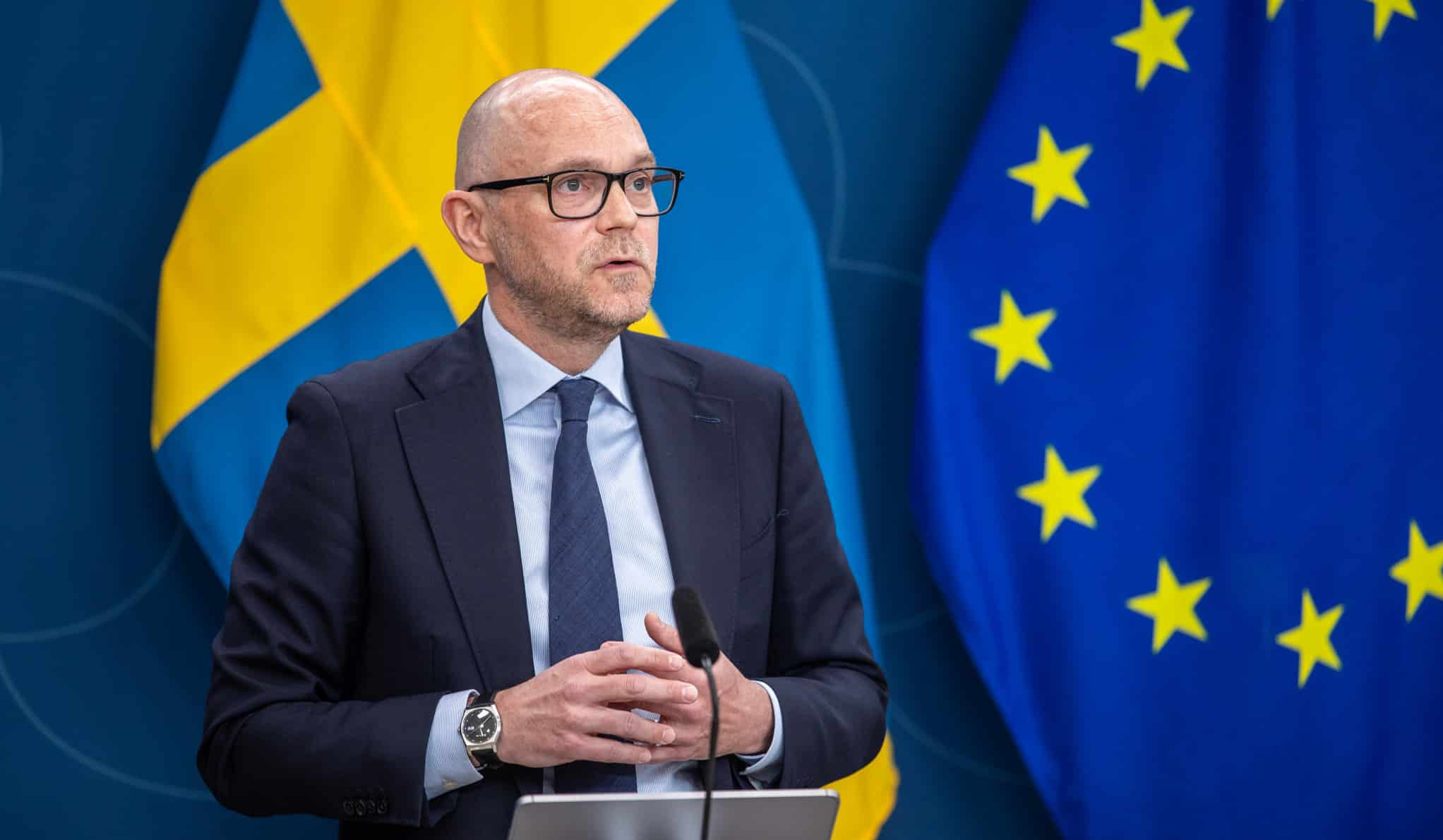 Vikarierande klimat- och miljöminister Johan Britz framför flaggor i Rosenbads pressrum.