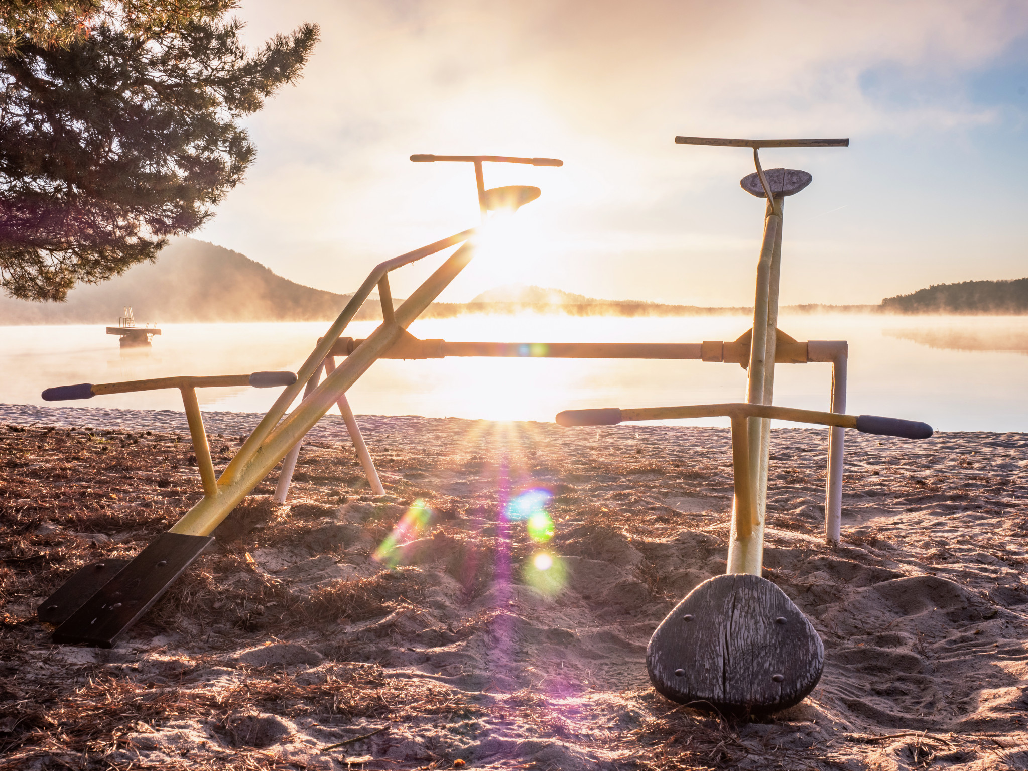Tvåsitsig gunga som vetter mot sjö.