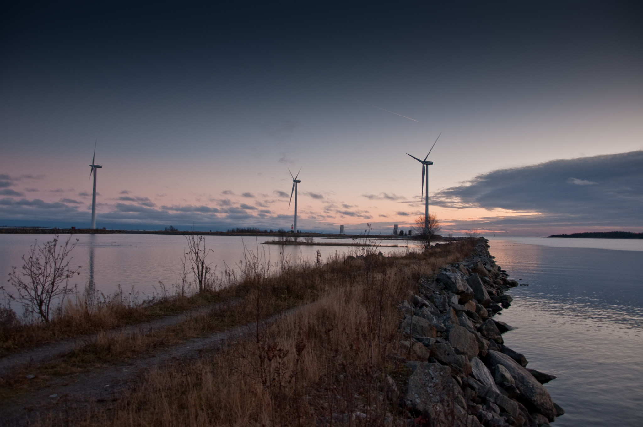 Vindkraftverk ute tillhavs i solnedgång