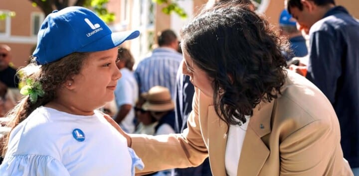 Simona Mohamsson pratar med en flicka iklädd Liberalernas kampanjkläder.